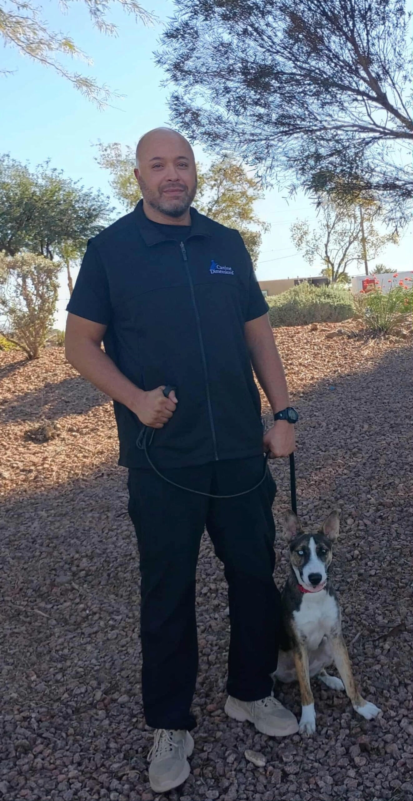 Jason Randall, Orange County, CA dog trainer standing with a black and white dog